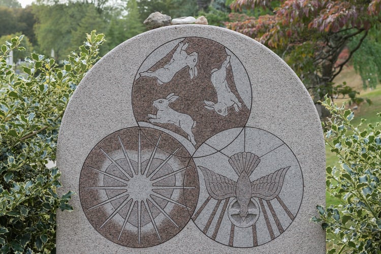 Rabbits, a descending dove, and an intricate heart sit carved into this unique and incredibly detailed custom LAURENTIAN ROSE® granite memorial. 