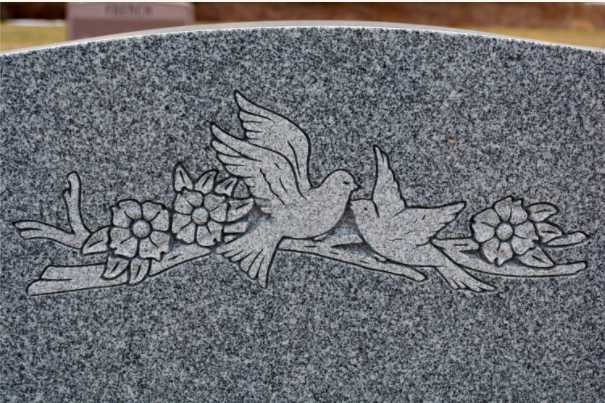 Symbolic headstone marker carved into Blue Gray granite representative of sentimental tattoos