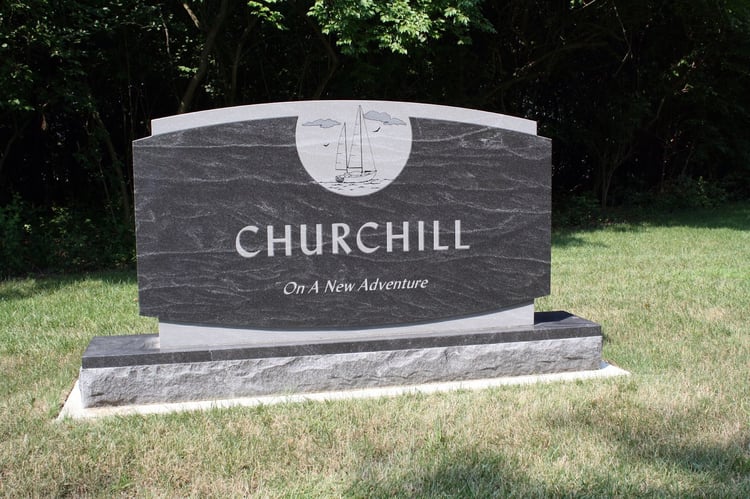 Black Mist granite headstone memorial with inscription of adventure and detail of sailboat element