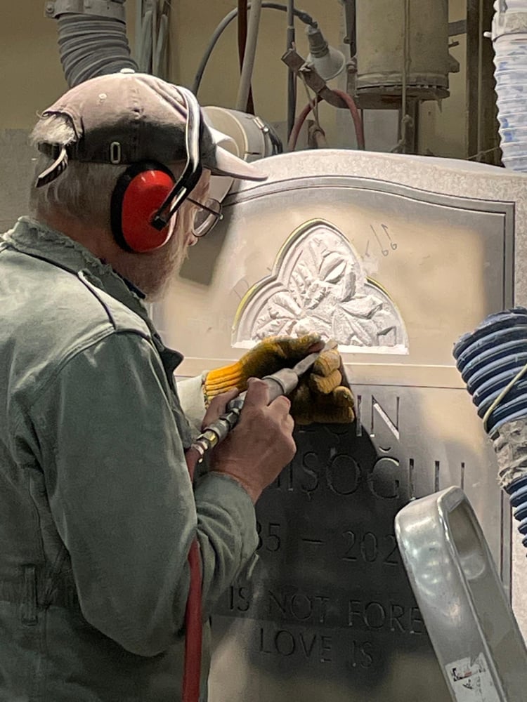 Rock of Ages Master Sculptor Stanley Lutostanski uses pneumatic tools to hand carve a family memorial